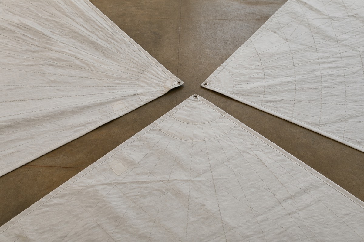 Radial and crosscut sail panels marked with seam lines on a loft floor